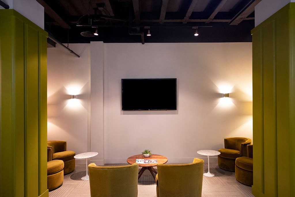 A room with a white wall and a black screen on the wall.