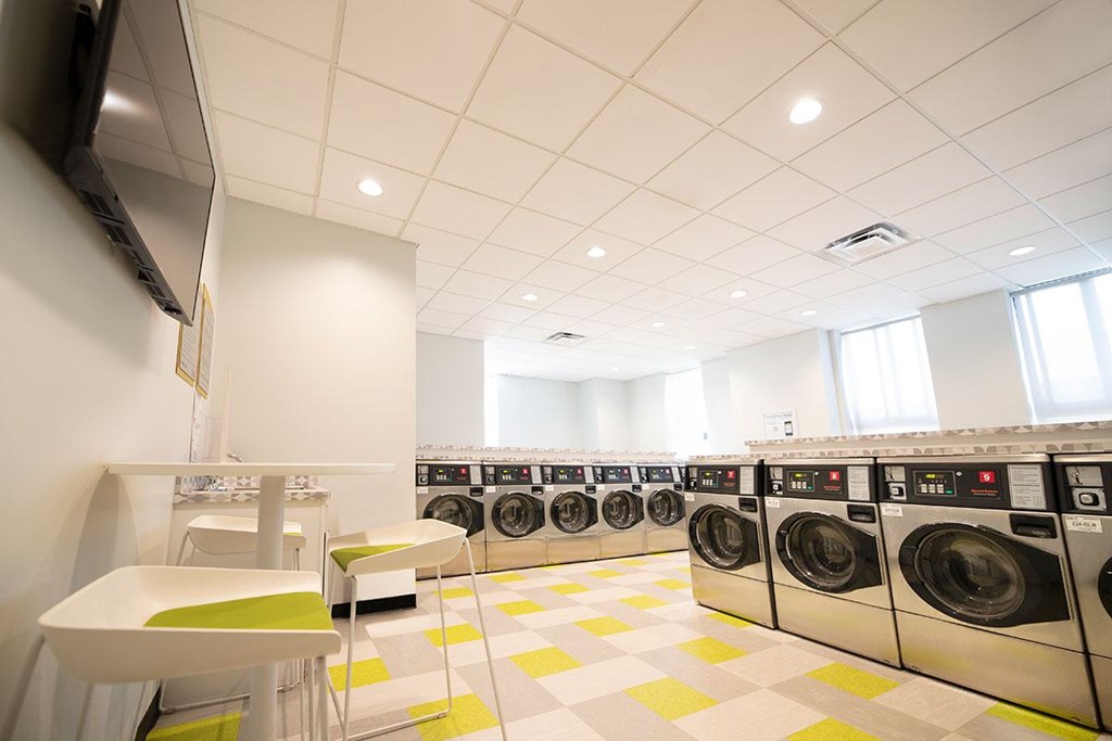 A laundromat with washers and dryers lined up.