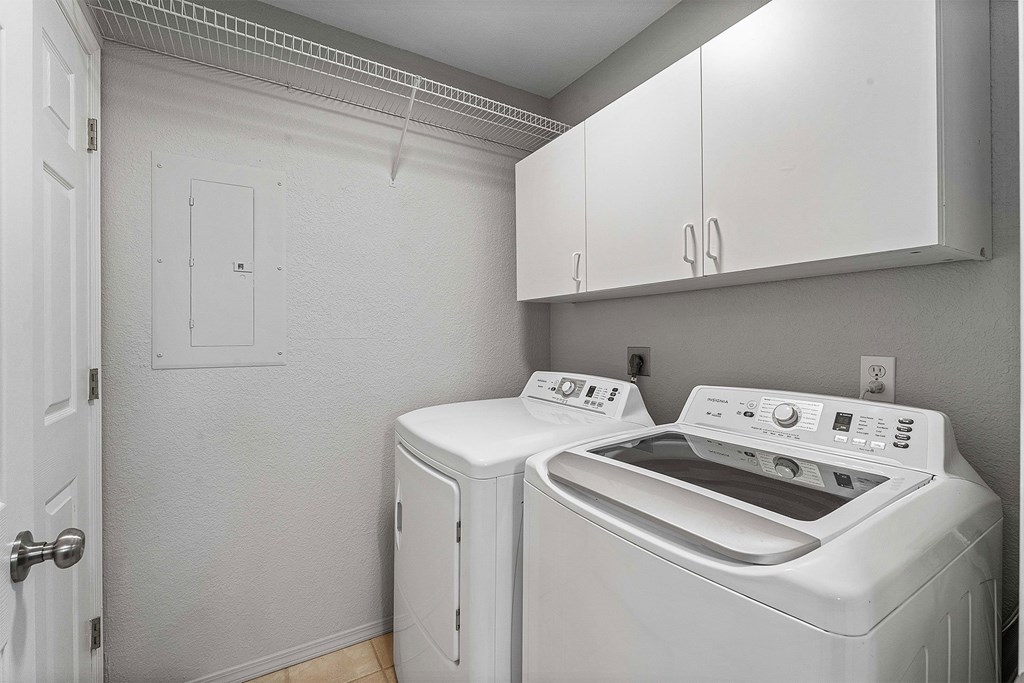 A white laundry room with a washer and dryer.