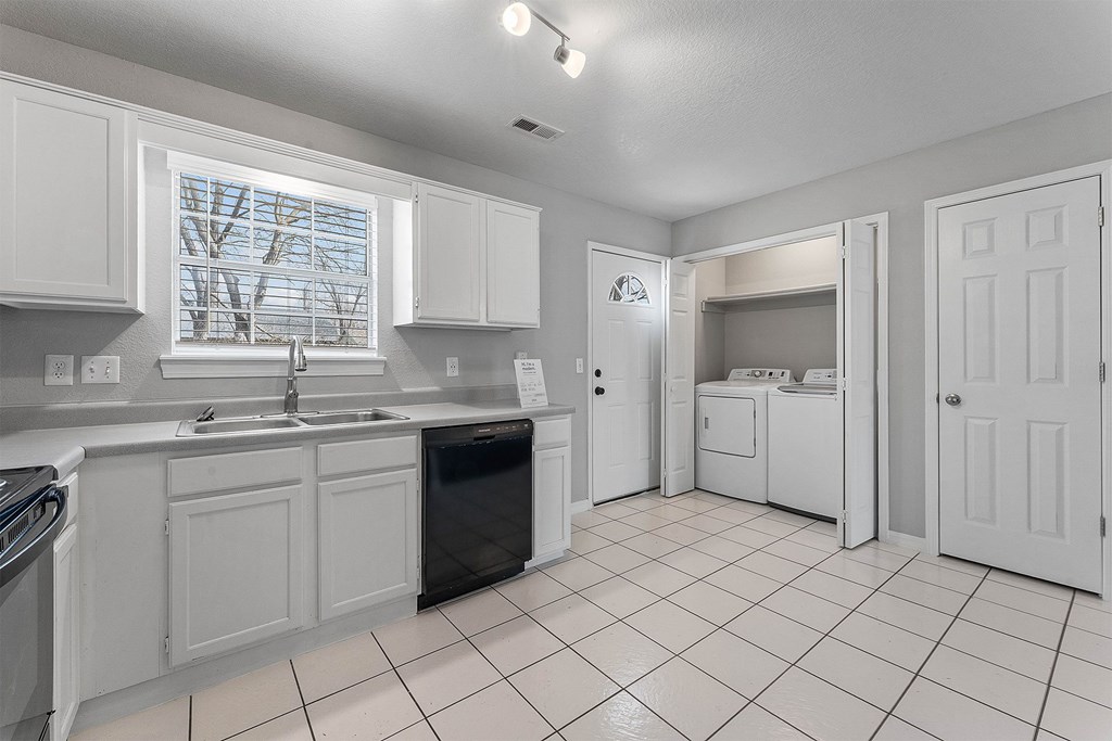 A kitchen with white cabinets and appliances.