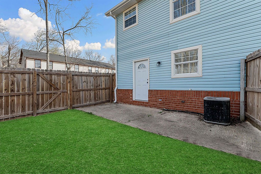 A blue house with a white door and a brown fence.
