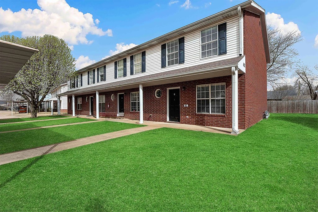 A red brick building with white trim and a black door.