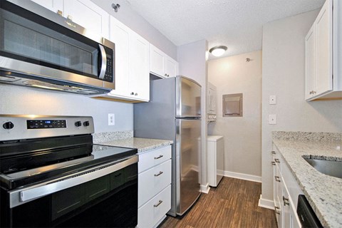 A kitchen with a stove, microwave, and refrigerator.