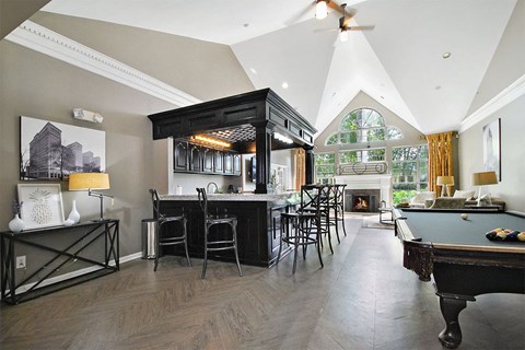 A billiard table is in the corner of a room with a pool table.