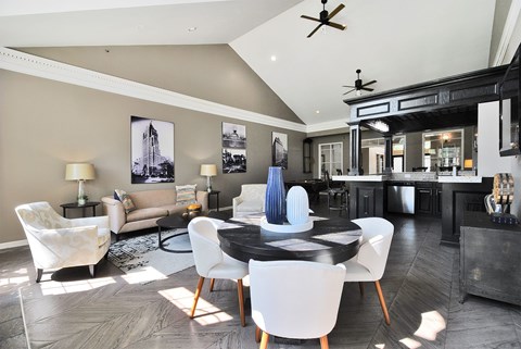 A modern dining room with a black table and white chairs.