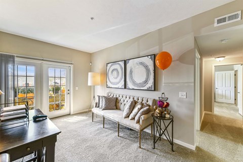 A living room with a couch, a table, and a painting on the wall.