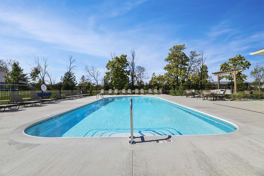 A large outdoor swimming pool with a blue tinted water.
