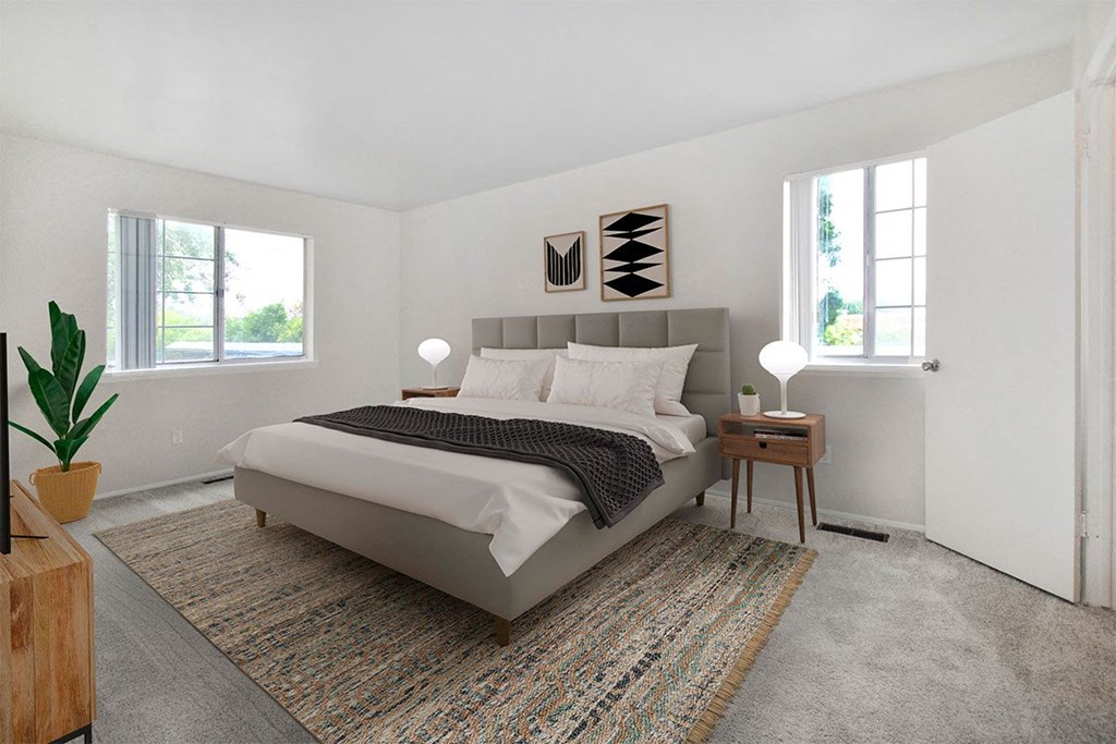 a bedroom with a bed and two windows