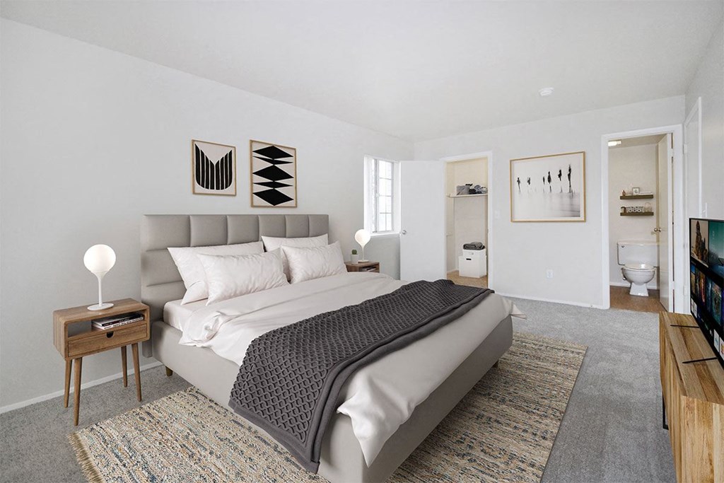 a white bedroom with a bed and a bathroom