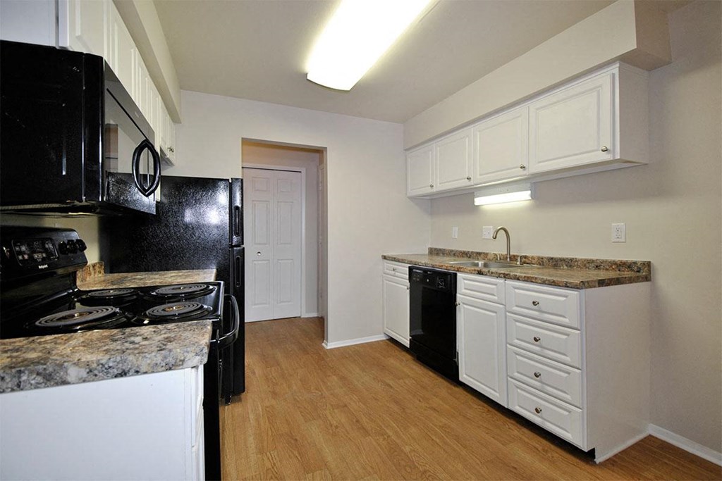 a kitchen with black appliances and white cabinets