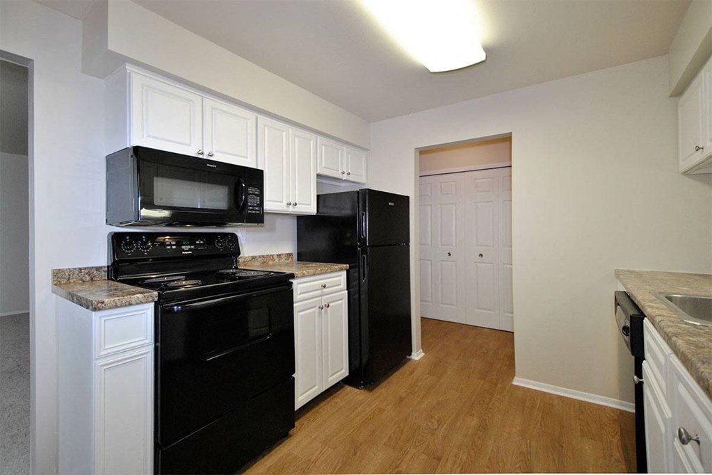 a kitchen with black appliances and white cabinets