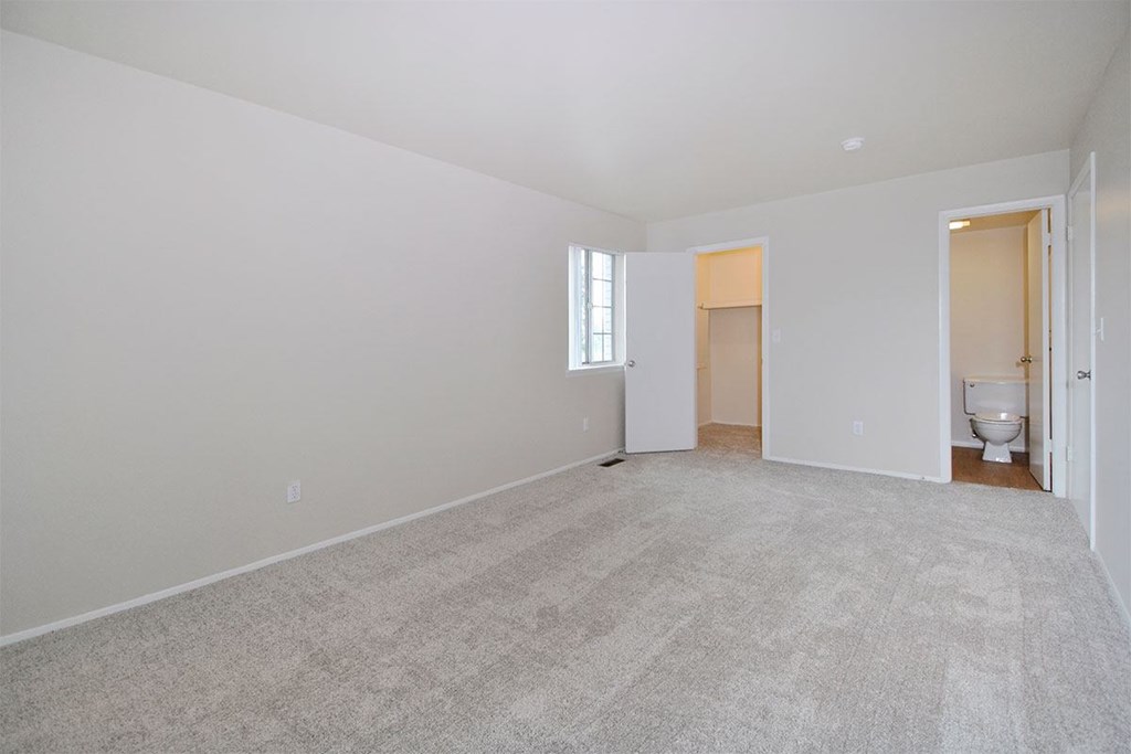 an empty living room with a toilet and a bathroom