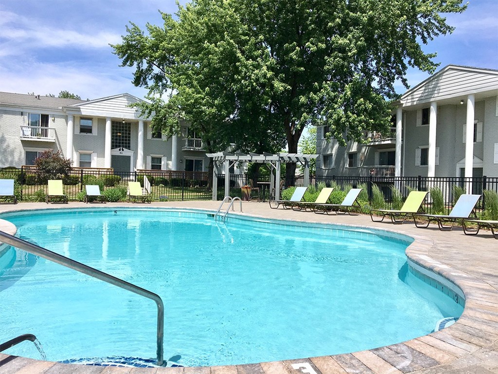 a large swimming pool in front of an apartment building