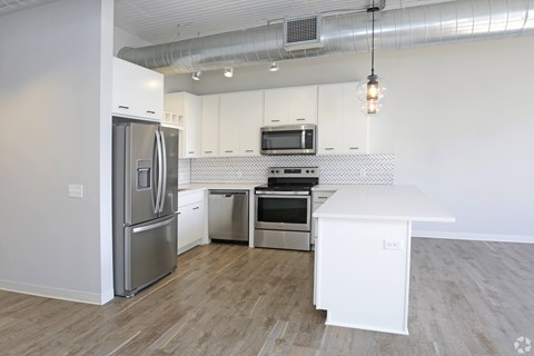 A modern kitchen with a white refrigerator, stove, and oven.