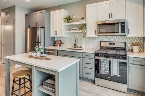a kitchen with an island and a stove and a microwave