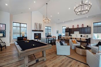 a large living room with a pool table in the middle