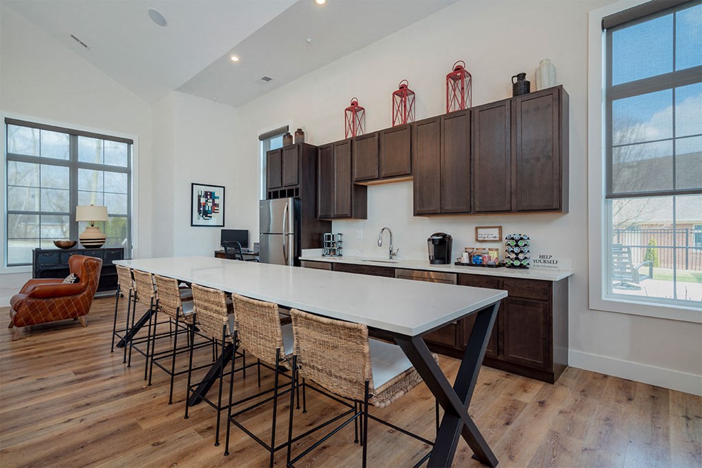 a kitchen with a large white table and chairs