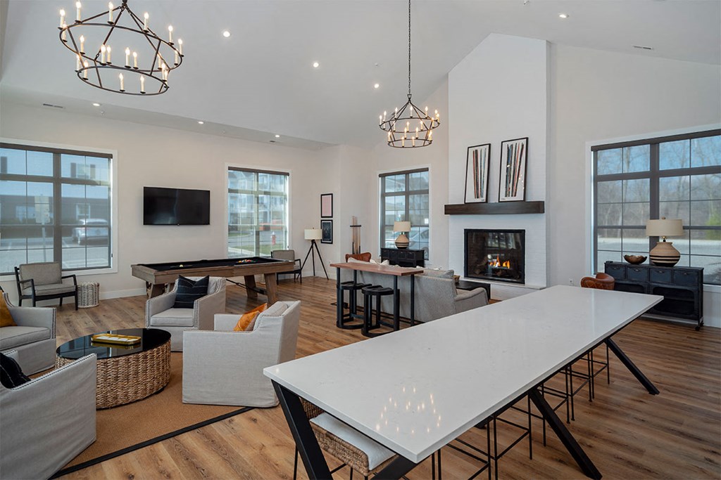 a large living room with a fireplace and a white table