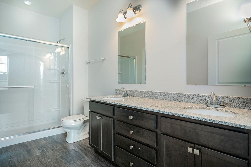 a bathroom with a toilet sink and mirror and a shower