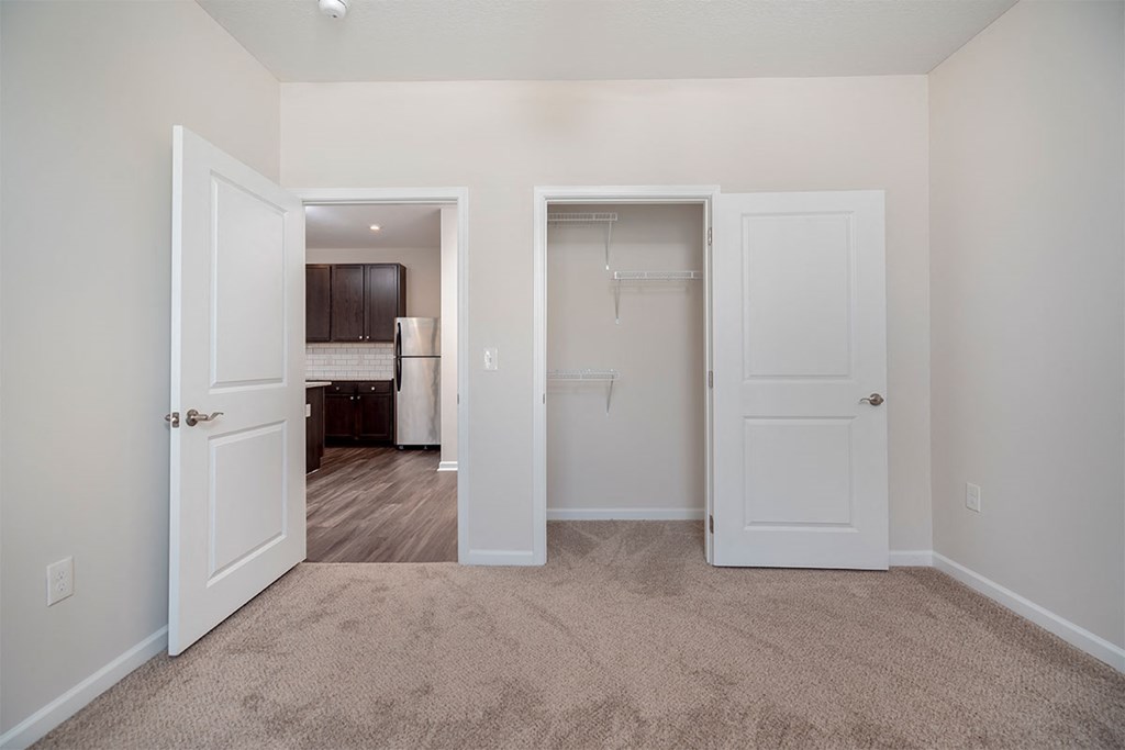 a bedroom with two closets and a door to a bathroom