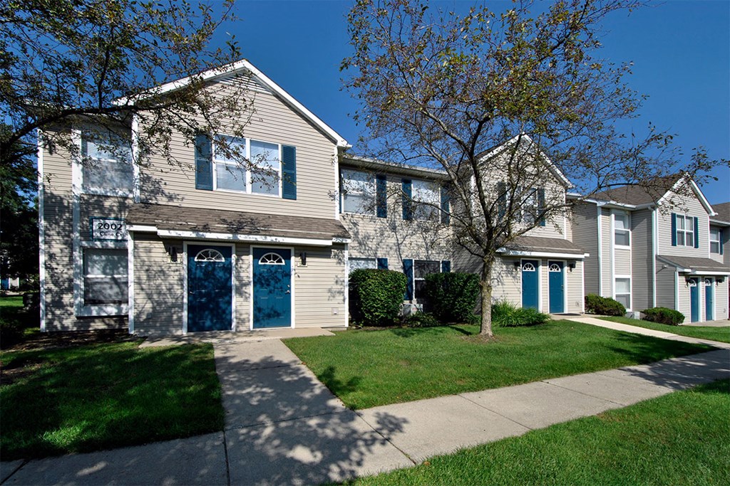 a row of houses with blue doors on a sidewalk