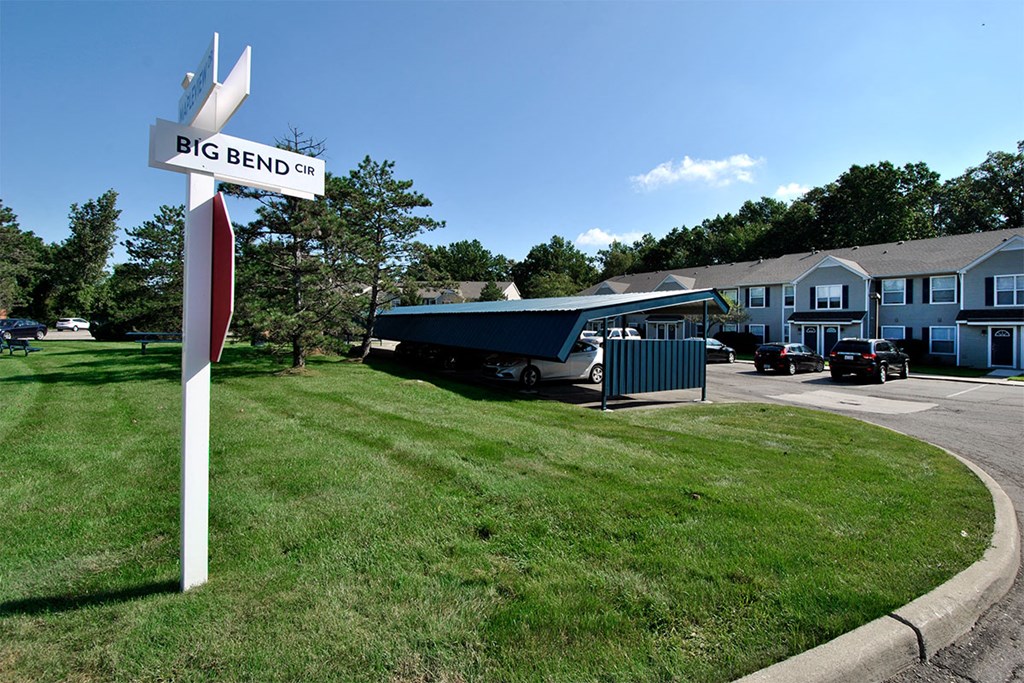 a big bend street sign in front of a yard with houses