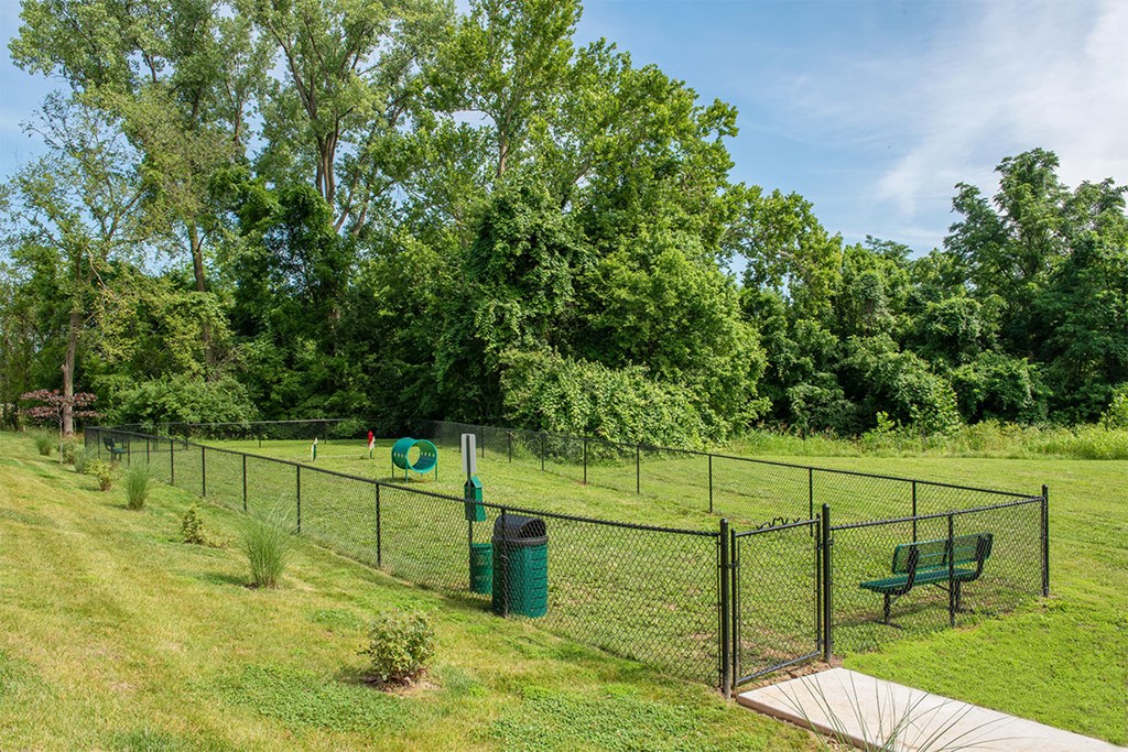 a fenced in area with a frisbee in it and a park bench