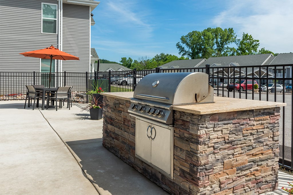 our outdoor kitchen has a grill and a pizza oven on our patio
