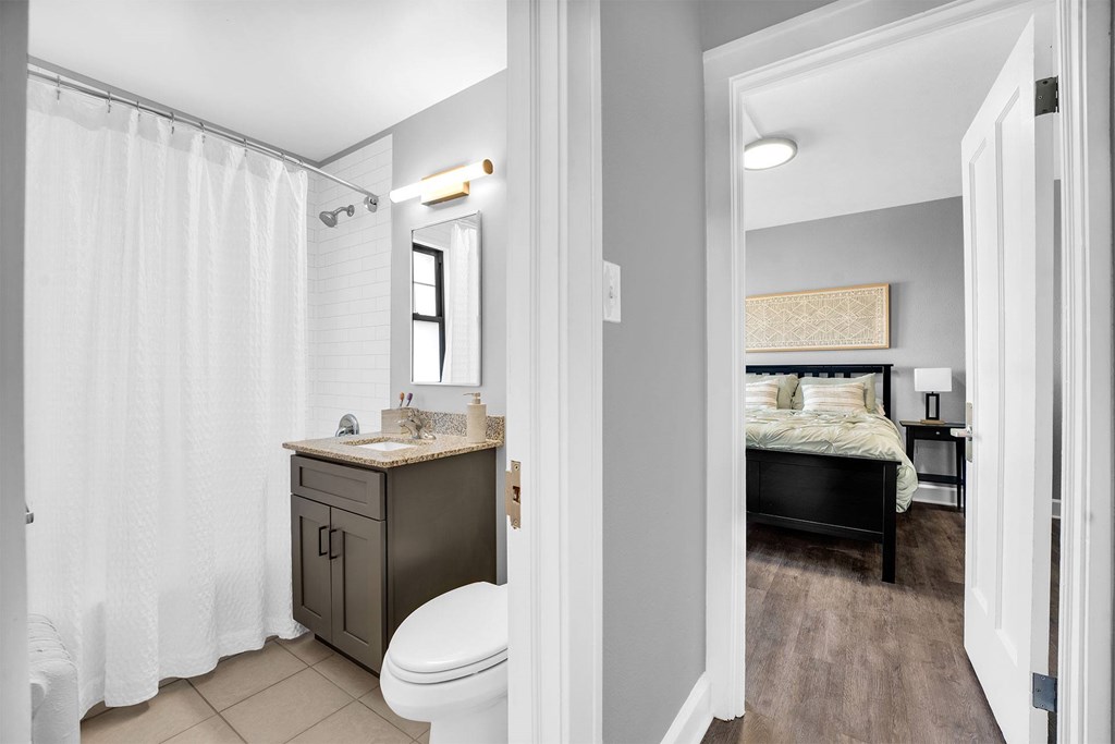 A bathroom with a toilet, sink, and shower curtain.