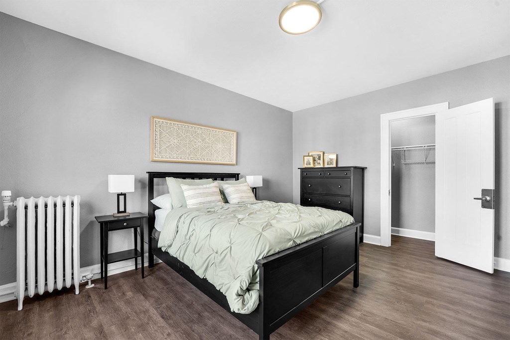 A bedroom with a bed, nightstand, and lamp.