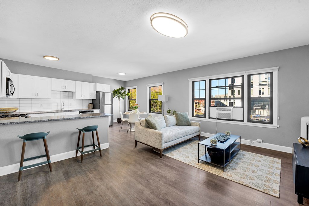 A modern kitchen with white cabinets and a bar area.