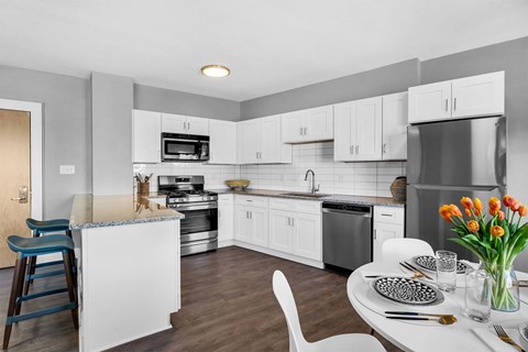 A modern kitchen with a dining table set for two.