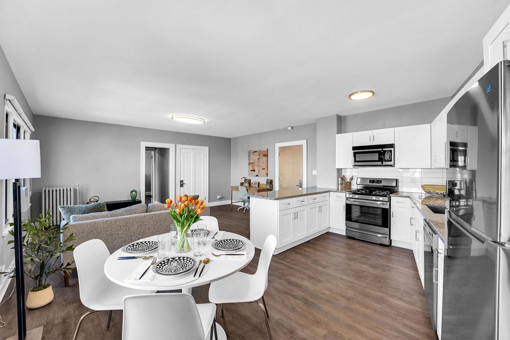 A modern kitchen with a dining table set for four.