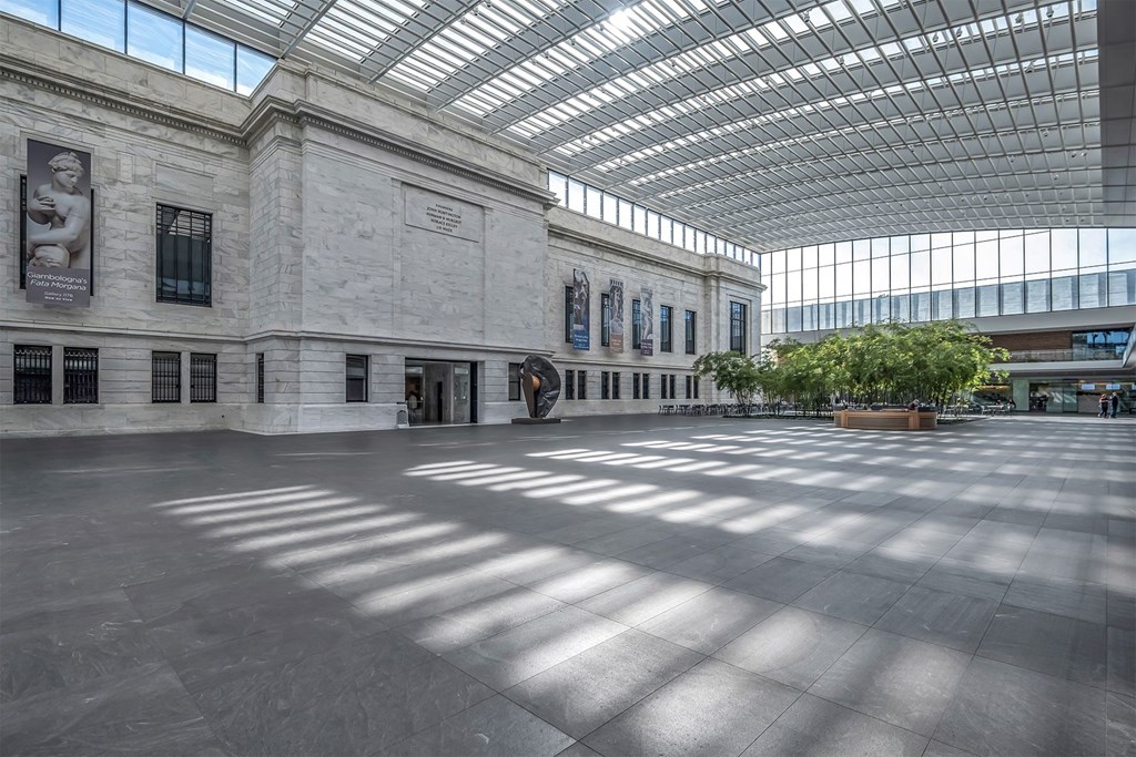 The interior of a museum with a glass roof and walls.