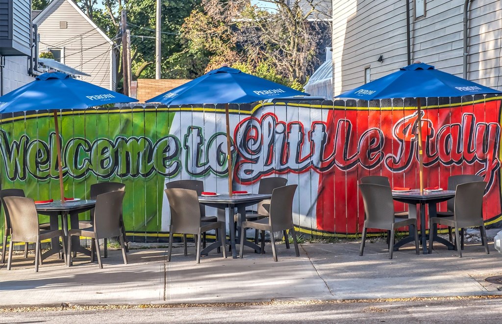 A restaurant with blue umbrellas and a sign that says "Welcome to Cville Fay".