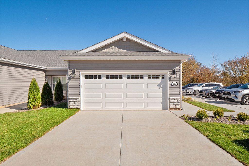 a house with a white garage door in front of a driveway