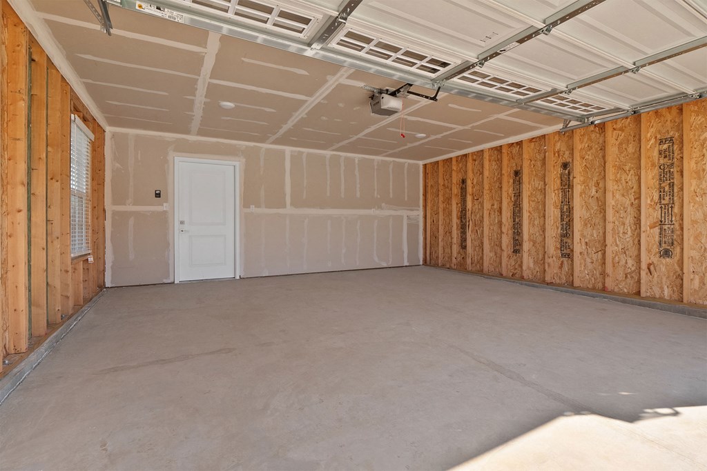 a room with a concrete floor and wooden walls and a white door