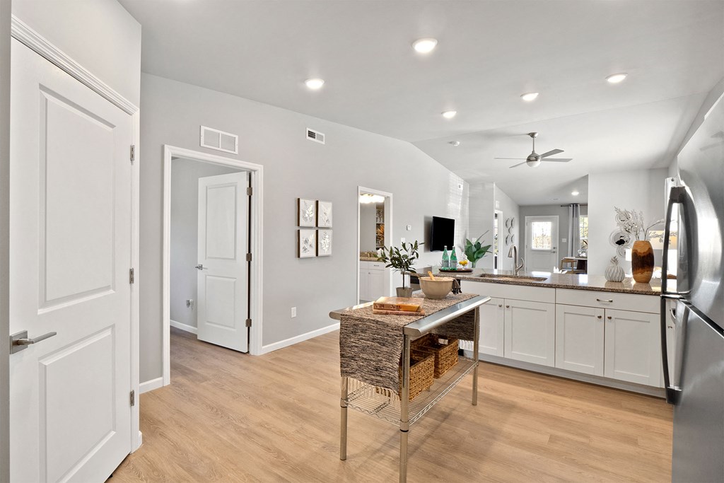 a kitchen with white cabinets and a table with a basket