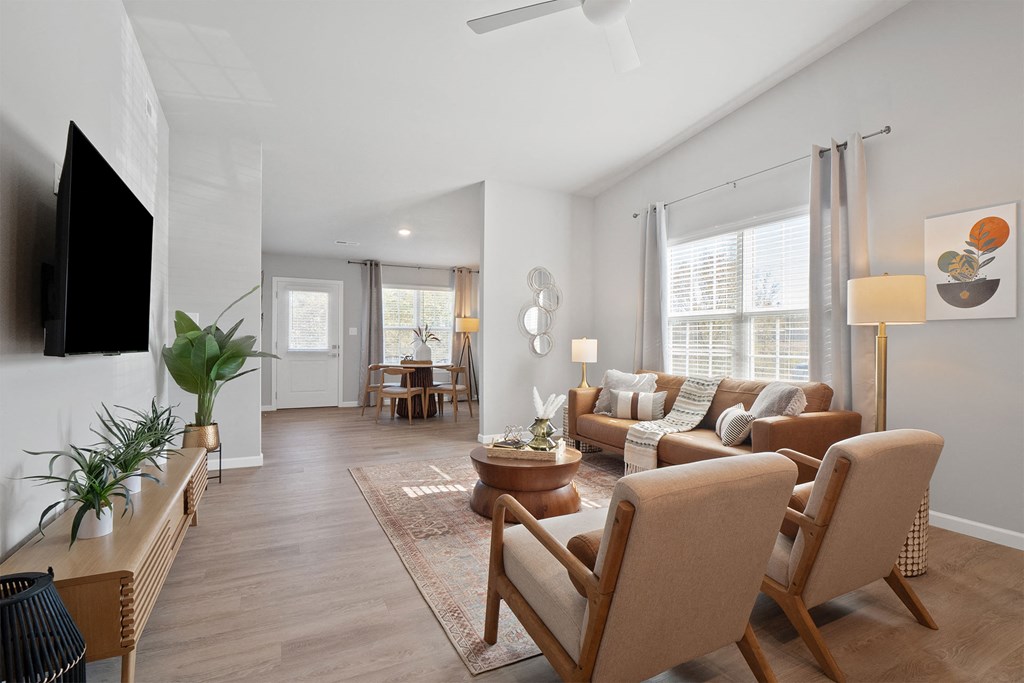 a living room with a couch and chairs and a tv