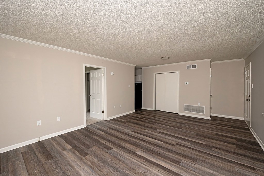 A room with wood flooring and white walls.