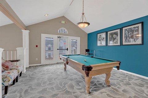 A pool table in a room with a carpeted floor.