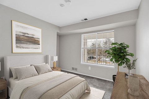 A bedroom with a large bed and a painting on the wall.