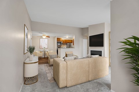 A living room with a beige couch and a television on the wall.