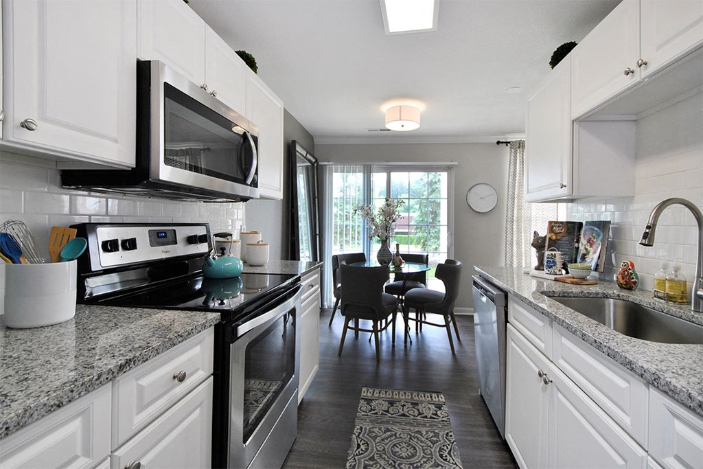 a kitchen with granite counter tops and black appliances
