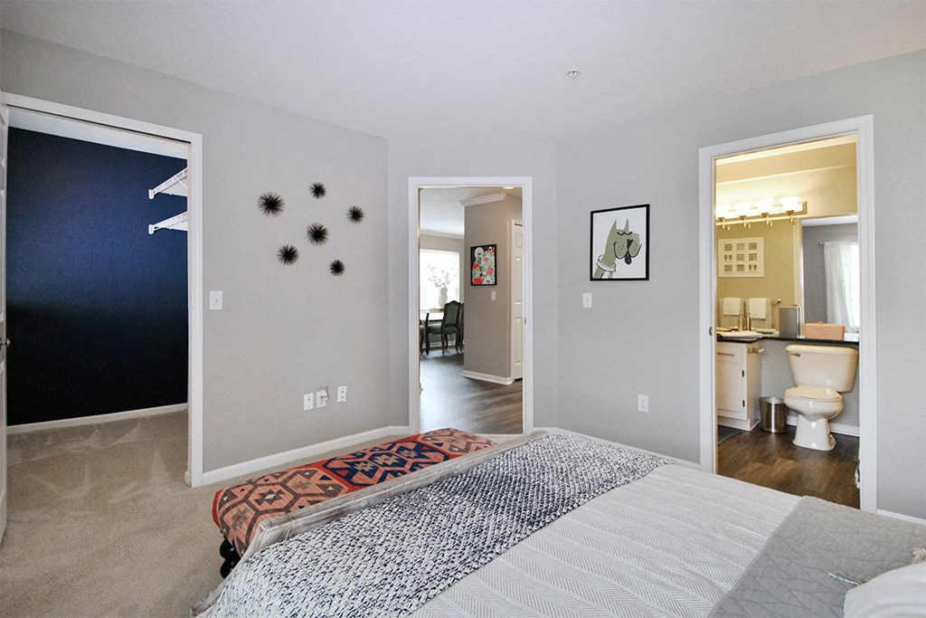 a bedroom with a bed and a bathroom with a toilet