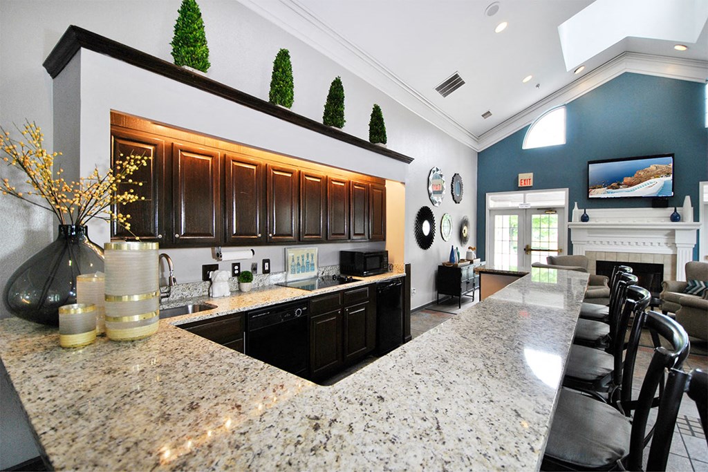 a kitchen with granite counter tops and a bar with chairs