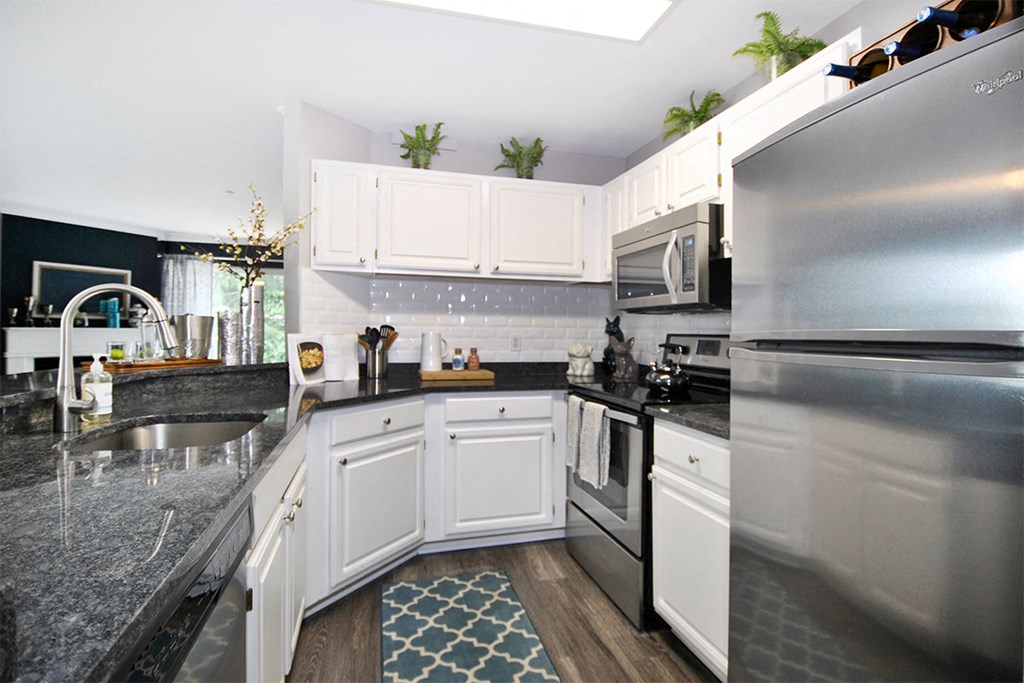 a kitchen with stainless steel appliances and white cabinets