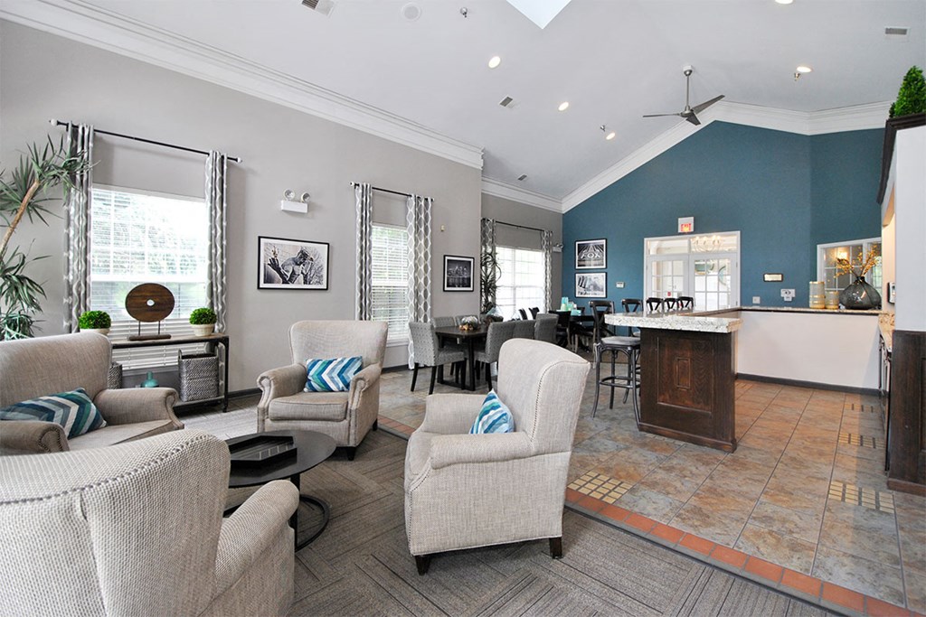 a living room with couches and chairs and a kitchen