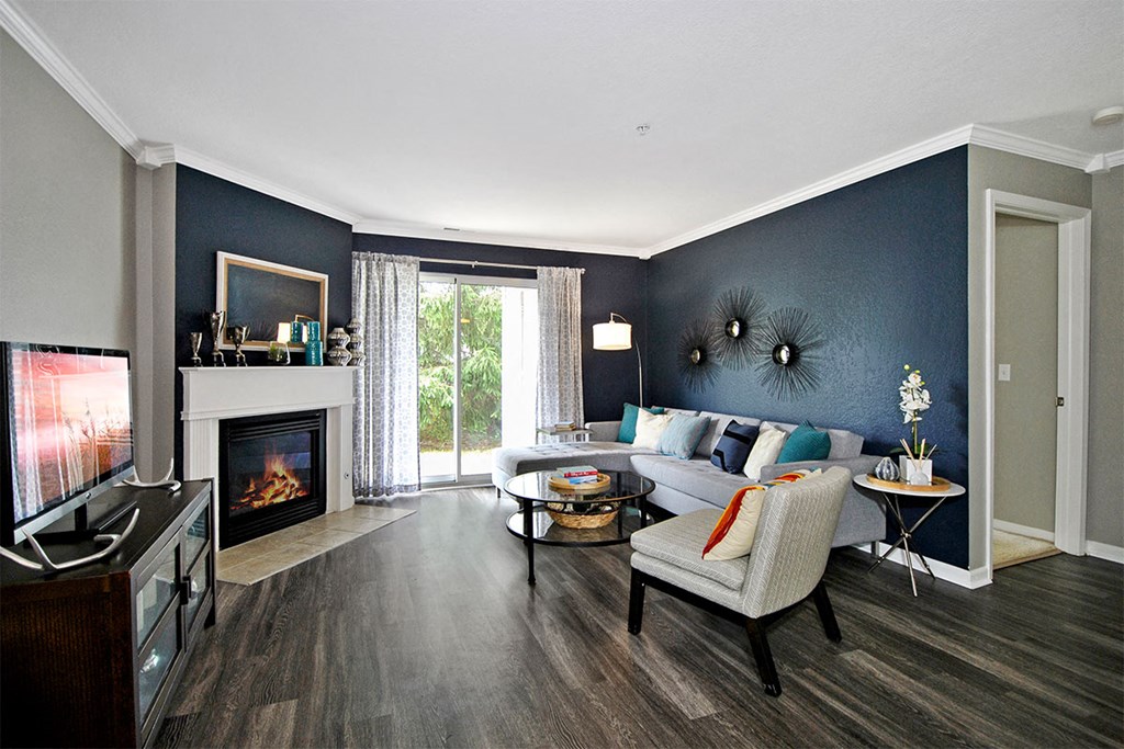 a living room with a blue accent wall and a fireplace