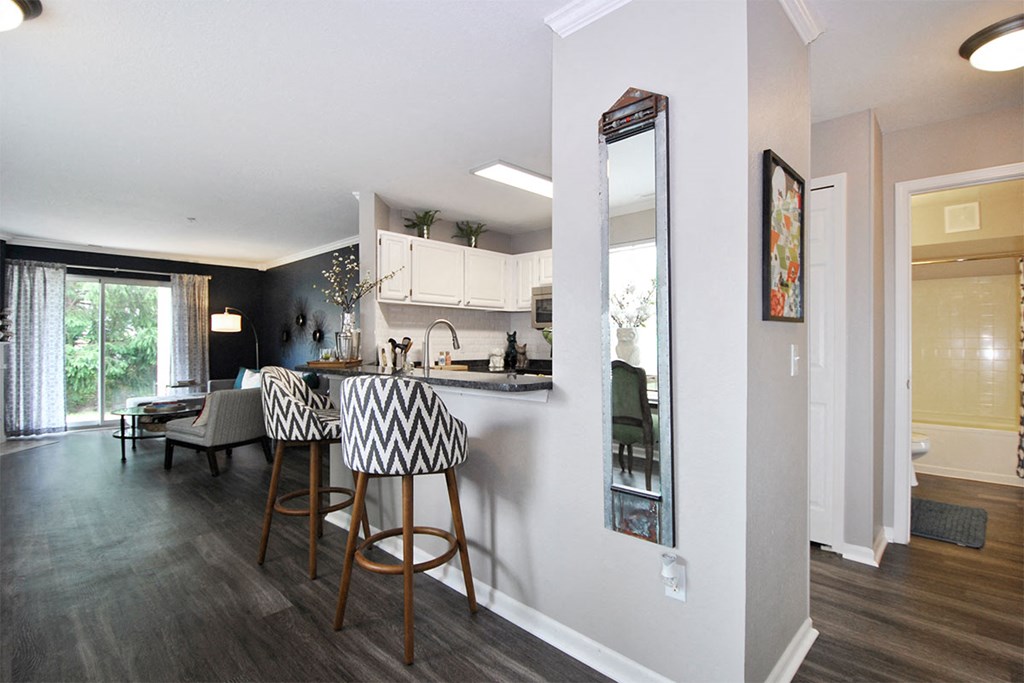 a kitchen and living room with a bar and stools
